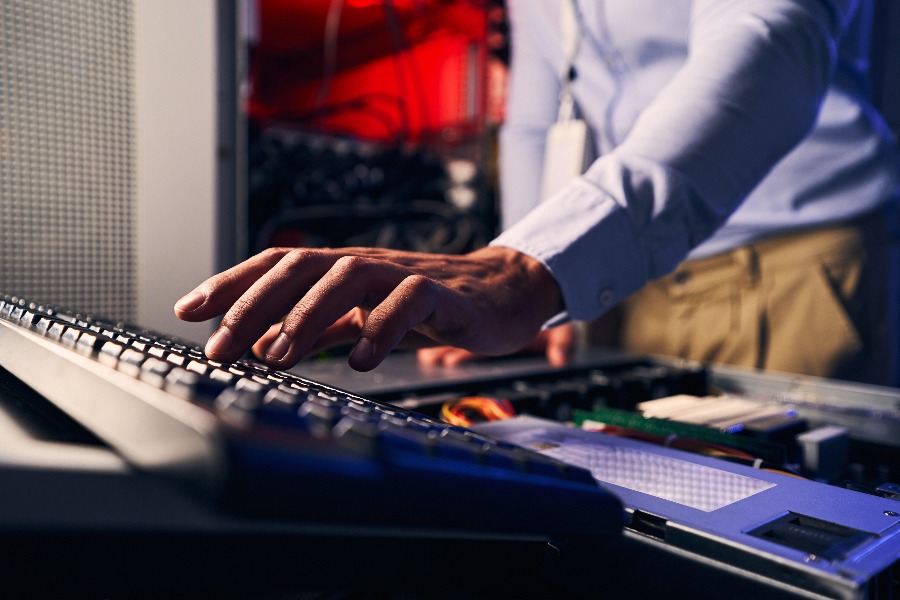 Cropped photo of experienced male system administrator upgrading computer hardware in data center